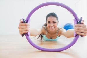 lächelnde Frau mit Übungsring im Fitnessstudio foto