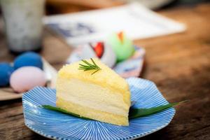 Nahaufnahme Frischkäse-Chiffon-Kuchen in einem gekachelten Teller, dekoriert mit Rosmarinblättern, Kuchen im japanischen Stil foto