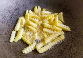 Pommes Frites werden in der alten Metallpfanne mit der Ölpalme gebraten. foto