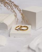 Ehering auf weißem Stein. Der Schmuckring kann präsentiert und verkauft werden. Der Ehering ist ein Zeichen der Liebe des Paares. Perlen und Diamanten vervollständigen die Schönheit des Rings. Fokusunschärfe. foto