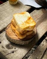 Brotscheiben werden leicht gebacken und auf Holzplatten gestapelt. Holzhintergrund für ein ästhetisches Aussehen. kann für Hintergründe oder Werbung verwendet werden. foto
