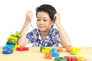 schöner asiatischer junge spielt buntes holzblockspielzeug foto