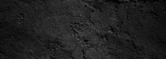 schwarze wand beängstigend oder dunkelgrauer rauer körniger steinbeschaffenheitshintergrund. schwarzer Beton für den Hintergrund. foto