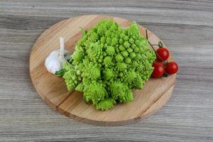 Romanesco-Kohl auf Holzplatte und Holzhintergrund foto