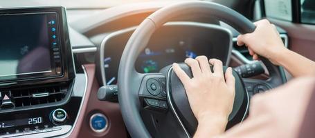 Fahrerin, die während der Fahrt auf der Verkehrsstraße ein Auto hupt und das Lenkrad im Fahrzeug von Hand steuert. Reise-, Reise- und Sicherheitstransportkonzepte foto