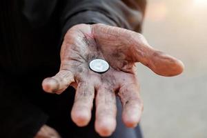 Hand alter Mann, der wegen des Hungers um Geld bettelt Vintage-Ton foto