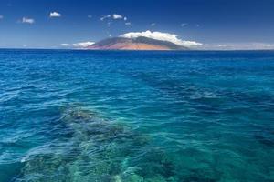 Riff in klarem Wasser mit West Maui Bergen, Hawaii, USA foto