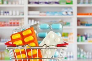 Medizin Pille Tablette im Einkaufskorb mit Apotheke Drogerieregalen verschwommenen Hintergrund foto