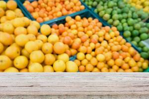 Holztischplatte über frischen Orangen auf dem Markt foto