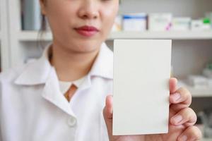 Apotheker, der leeres Papier in der Apotheke hält foto