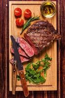 Ribeye-Steak mit Rucola und Tomaten. foto