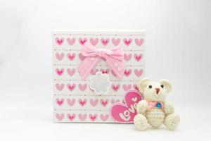 Valentinstag Szene Rosa Herzmuster Geschenkbox mit einem Teddybären auf weißem Hintergrund foto