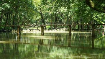 Eine alte Holzbrücke überquert den Fluss im Dorf des Porzellans foto