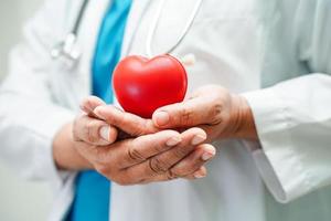 asiatische Ärztin mit rotem Herz für die Gesundheit im Krankenhaus. foto