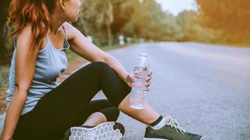 Frauen trainieren auf der Straße. Naturpark. gesundes Wasser trinken. asiatische Frauen foto