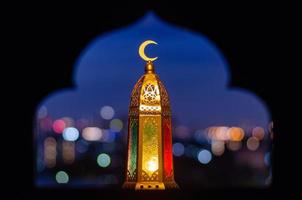 Laterne, die oben ein Mondsymbol haben, mit verschwommenem Fokus des Papierschnitts für Moscheenformhintergrund. foto