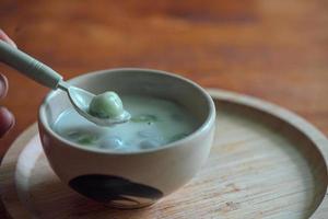 thailändisches Konfekt mit buntem Kugelmehl. thailändische Klebreisbällchen in cremigem Kokosmilchsirup. berühmtes thailändisches dessert bualoy foto