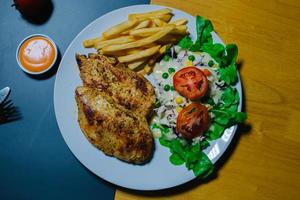 gegrilltes Steak und Salat, Pommes Frites auf Holzplatte foto