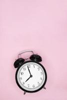 Schwarzer Vintage-Wecker zeigt 8 Uhr auf rosa Hintergrund. Platz kopieren foto
