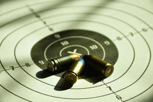 9-mm-Kugeln und 9-mm-Kugelgehäuse auf Zielpapier, weicher und selektiver Fokus foto