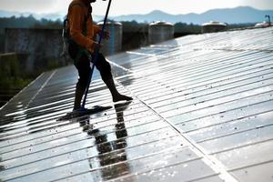 Photovoltaik-Techniker reinigten und wuschen die Oberfläche der Solarmodule, die Staub und Vogelkot aufwies foto