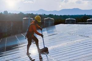 Photovoltaik-Techniker reinigten und wuschen die Oberfläche der Solarmodule, die Staub und Vogelkot aufwies foto