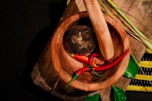 Mörser und Stößel aus Holz mit Kräutern. geeignet für traditionelle Lebensmittelkampagne foto
