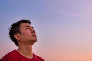 asiatischer mann, der zum himmel aufschaut. Emotion Gesichtsausdruck. foto