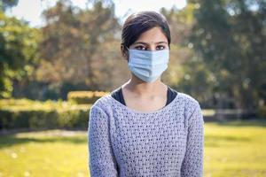 Indisches Teenager-Mädchen, junge Frau, die während der Coronavirus-Covid-19-Viruspandemie draußen eine Gesichtsmaske trägt.
