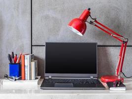 moderner Schreibtisch mit Laptop und Lampe foto
