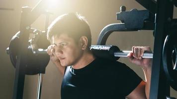 mann, der mit langhantel trainiert, krafttraining, das körperkraft im fitnessstudio in der morgensonne aufbaut.