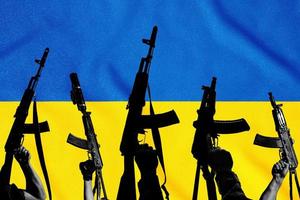 ukraine flagge und kampf militärische sturmgewehre ak 74 und ak 74u über ihren hintergrund, krieg und zerstörung. foto