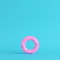 rosafarbener aufblasbarer Ring auf hellblauem Hintergrund in Pastellfarben foto