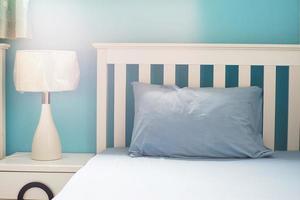 hellblaues Kissen auf weißem Bett im Schlafzimmer foto