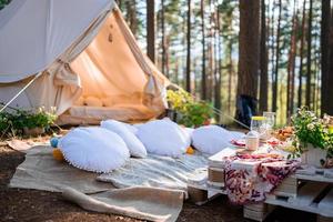 Picknick in der Natur, Tisch, Teppiche, Wigwam, Zelt, Kissen im Park. foto