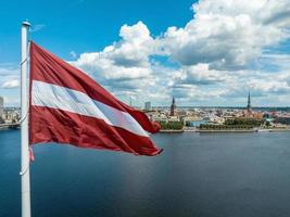 lettische Flagge mit dem Dom und einer Altstadt im Hintergrund foto