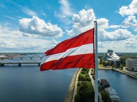 lettische Flagge mit Dom und Nationalbibliothek im Hintergrund foto