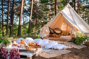 Picknick in der Natur, Tisch, Teppiche, Wigwam, Zelt, Kissen im Park. foto