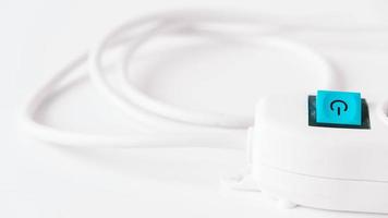 Modernes weißes elektrisches Verlängerungskabel mit einem Knopf auf weißem Hintergrund foto