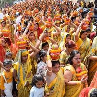 neu delhi, indien 03. april 2022 - frauen mit kalash auf dem kopf während des jagannath-tempels mangal kalash yatra, indische hindu-anhänger tragen irdene töpfe mit heiligem wasser mit einer kokosnuss darauf foto