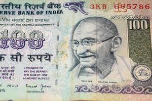 seltene alte Hundert-Rupien-Noten kombiniert auf dem Tisch, indisches Geld auf dem Drehtisch. alte indische Banknoten auf einem rotierenden Tisch, indische Währung auf dem Tisch foto