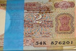 Seltene alte Zwei-Rupien-Noten kombiniert auf dem Tisch, indisches Geld auf dem Drehtisch. alte indische Banknoten auf einem rotierenden Tisch, indische Währung auf dem Tisch foto
