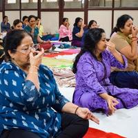 neu-delhi, indien, 19. juni 2022 - gruppen-yoga-übungssitzung für menschen verschiedener altersgruppen im balaji-tempel, vivek vihar, internationaler yoga-tag, große gruppe von erwachsenen, die an yoga-kursen im tempel teilnehmen foto