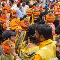 neu delhi, indien 03. april 2022 - frauen mit kalash auf dem kopf während des jagannath-tempels mangal kalash yatra, indische hindu-anhänger tragen irdene töpfe mit heiligem wasser mit einer kokosnuss darauf foto