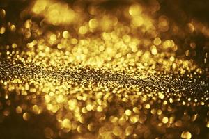 goldene glitzernde bokeh-beleuchtungsbeschaffenheit verschwommener abstrakter hintergrund für geburtstag, jahrestag, hochzeit, silvester oder weihnachten foto