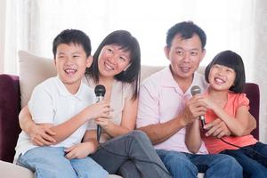 asiatische vierköpfige Familie, die Karaoke singt foto