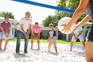 männliche Mehrgenerationenfamilie, die Volleyball im Garten spielt