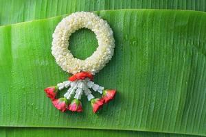 thailändische traditionelle jasmingirlande. symbol des muttertages in thailand auf bananenblatt foto