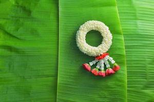 thailändische traditionelle jasmingirlande. symbol des muttertages in thailand auf bananenblatt foto