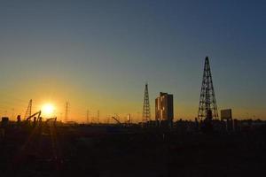 baustelle und strommast mit sonnenaufgangshimmel foto